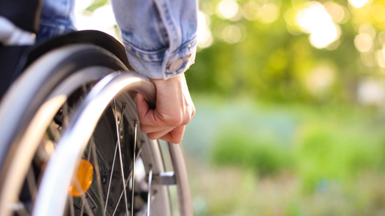 Homem aposentado por invalidez andando de cadeira de rodas